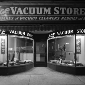 Night shot of the store's window display of their vacuums.